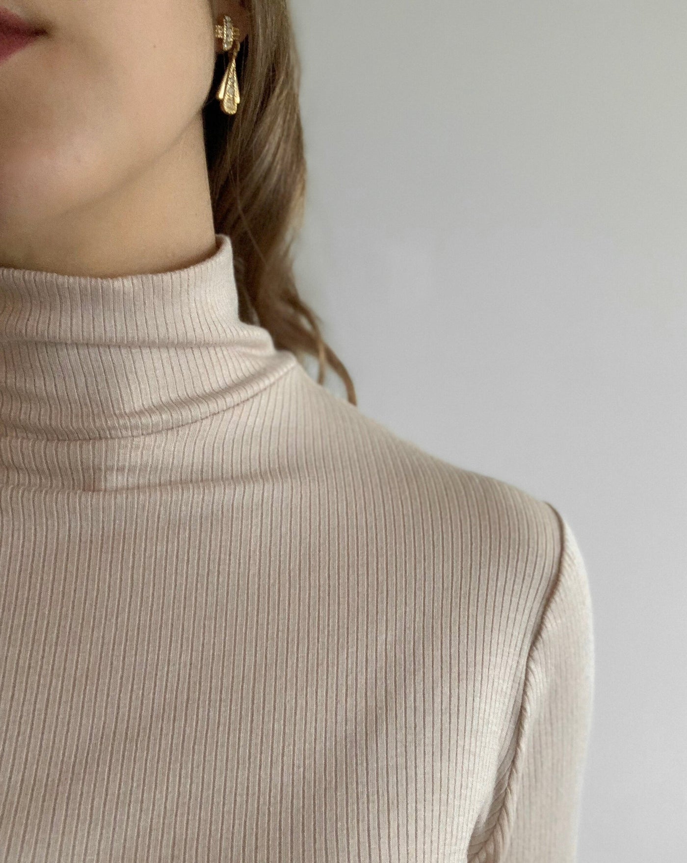 Ribbed beige Tencel longsleeve turtleneck worn with black denim.