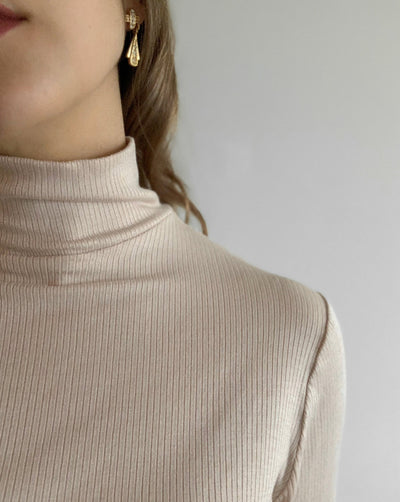Ribbed beige Tencel longsleeve turtleneck worn with black denim.