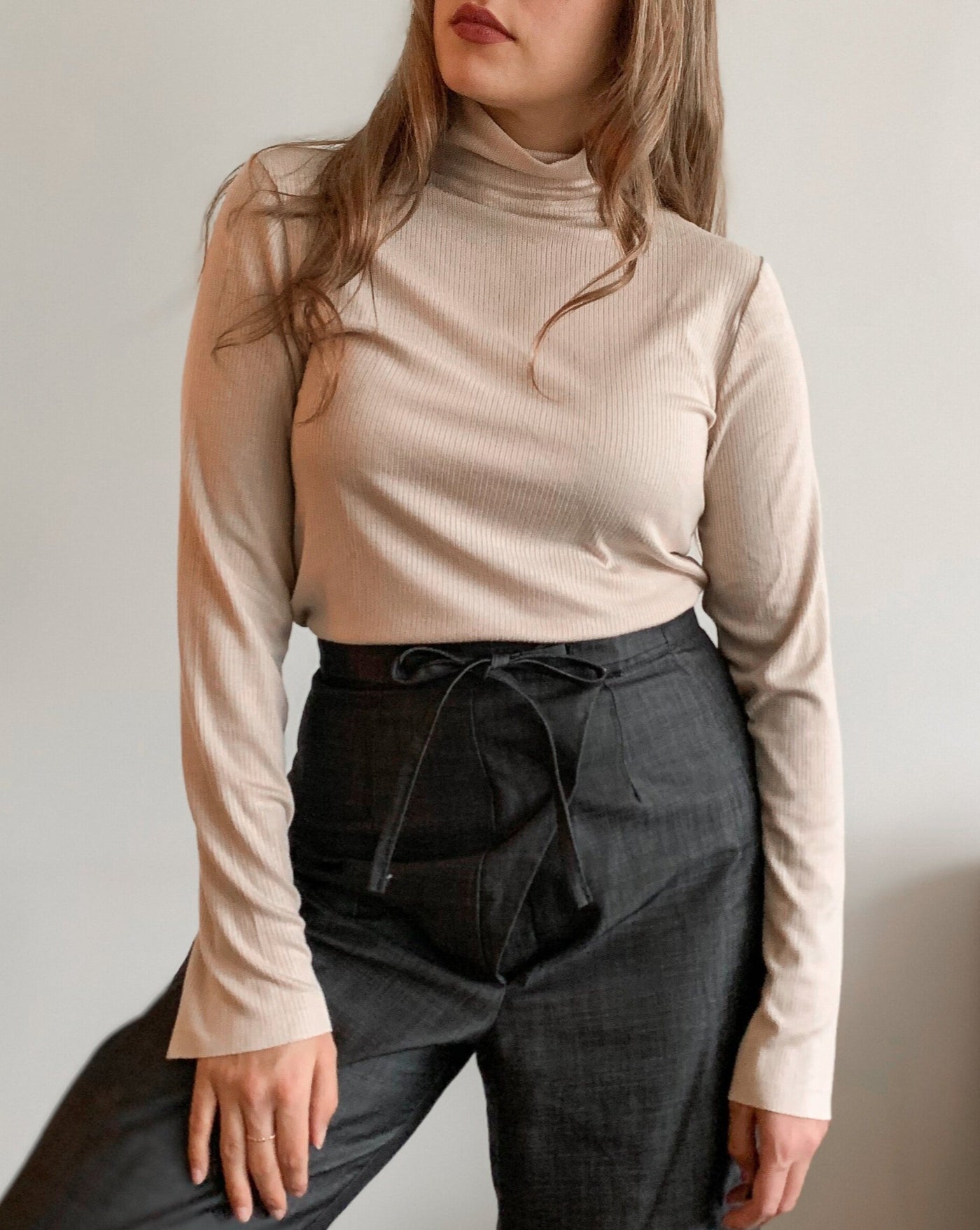 Ribbed beige Tencel longsleeve turtleneck worn with black denim.