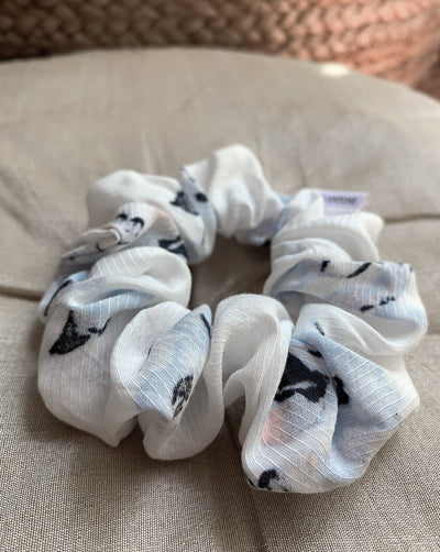 Light blue, pale pink, black and white floral reclaimed woven fabric scrunchie ethically sewn in Canada.
