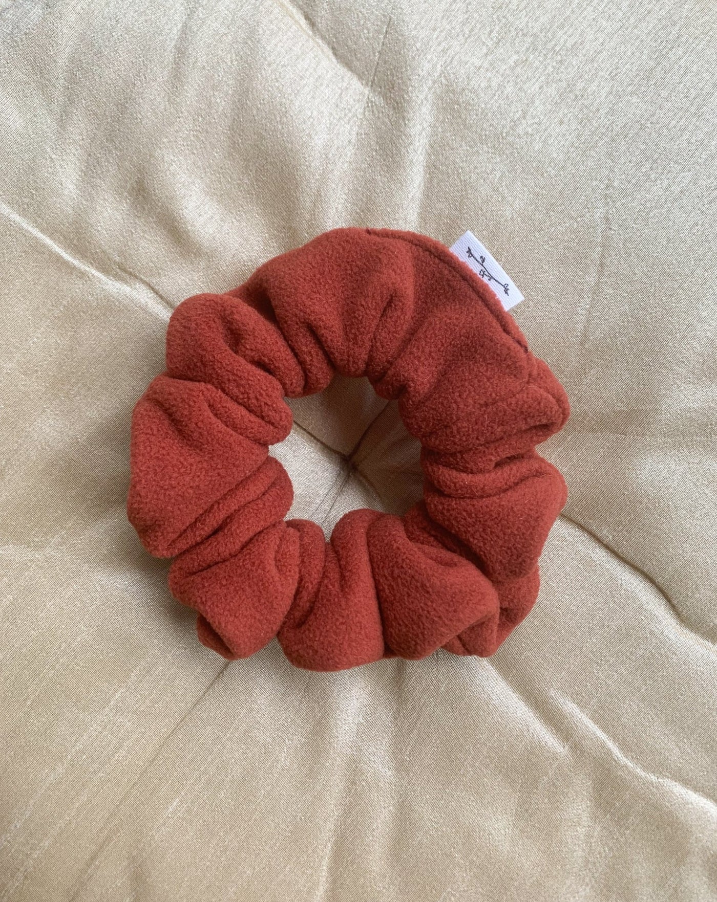 Recycled fleece pumpkin scrunchie flat lay.