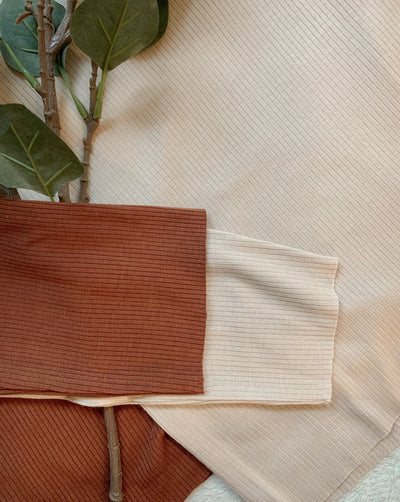 Ribbed Tencel longsleeve turtlenecks in beige and pecan brown with raw hem sleeves.