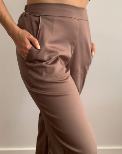 Light brown loose trousers made from organic cotton and tencel,with back elastic waistband worn with a beige turtleneck.