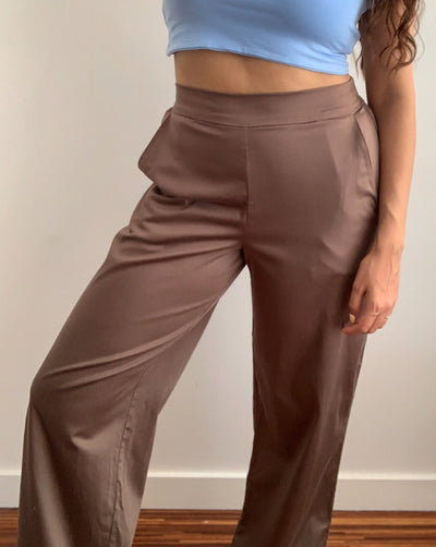 Light brown loose trousers made from organic cotton and tencel,with back elastic waistband worn with a beige turtleneck.