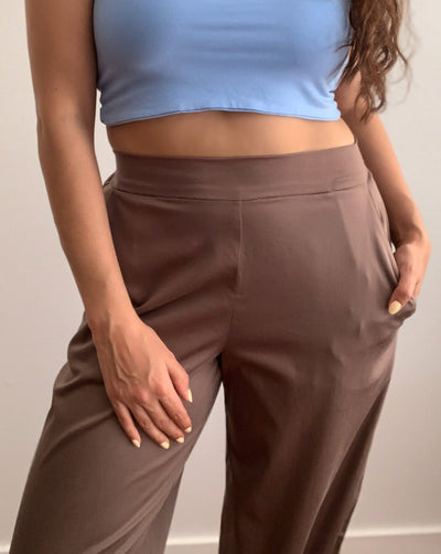 Light brown loose trousers made from organic cotton and tencel,with back elastic waistband worn with a beige turtleneck.